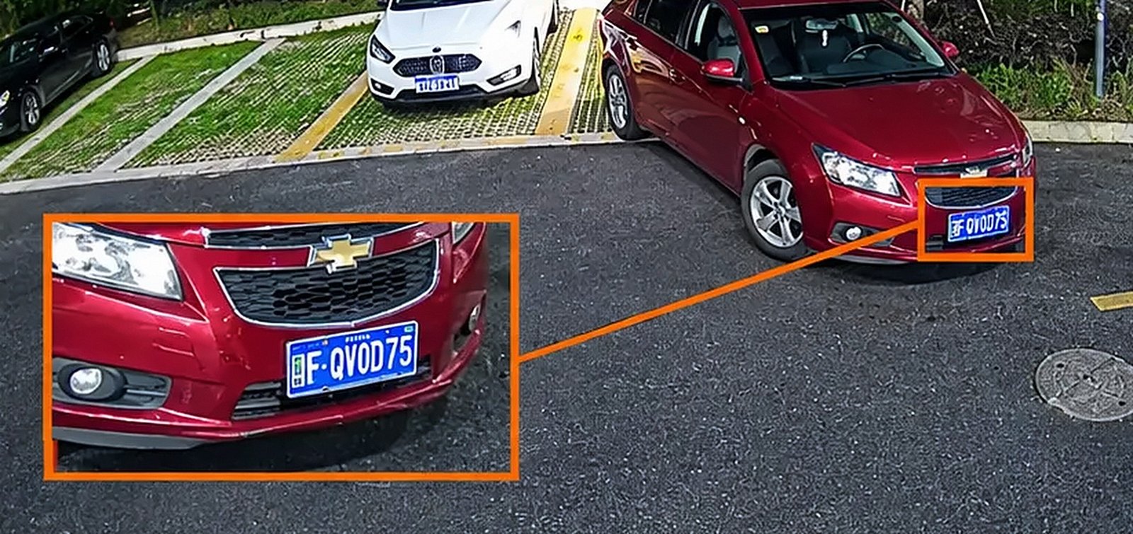Estacionamento à noite em imagem colorida, com a placa legível
