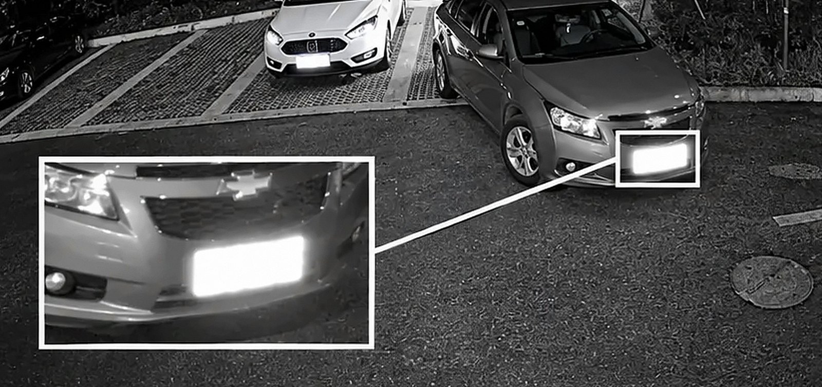 Mesmo estacionamento em preto e branco, placa estourada